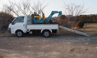 ユンボをトラックに乗せる天空のピオーネ農園